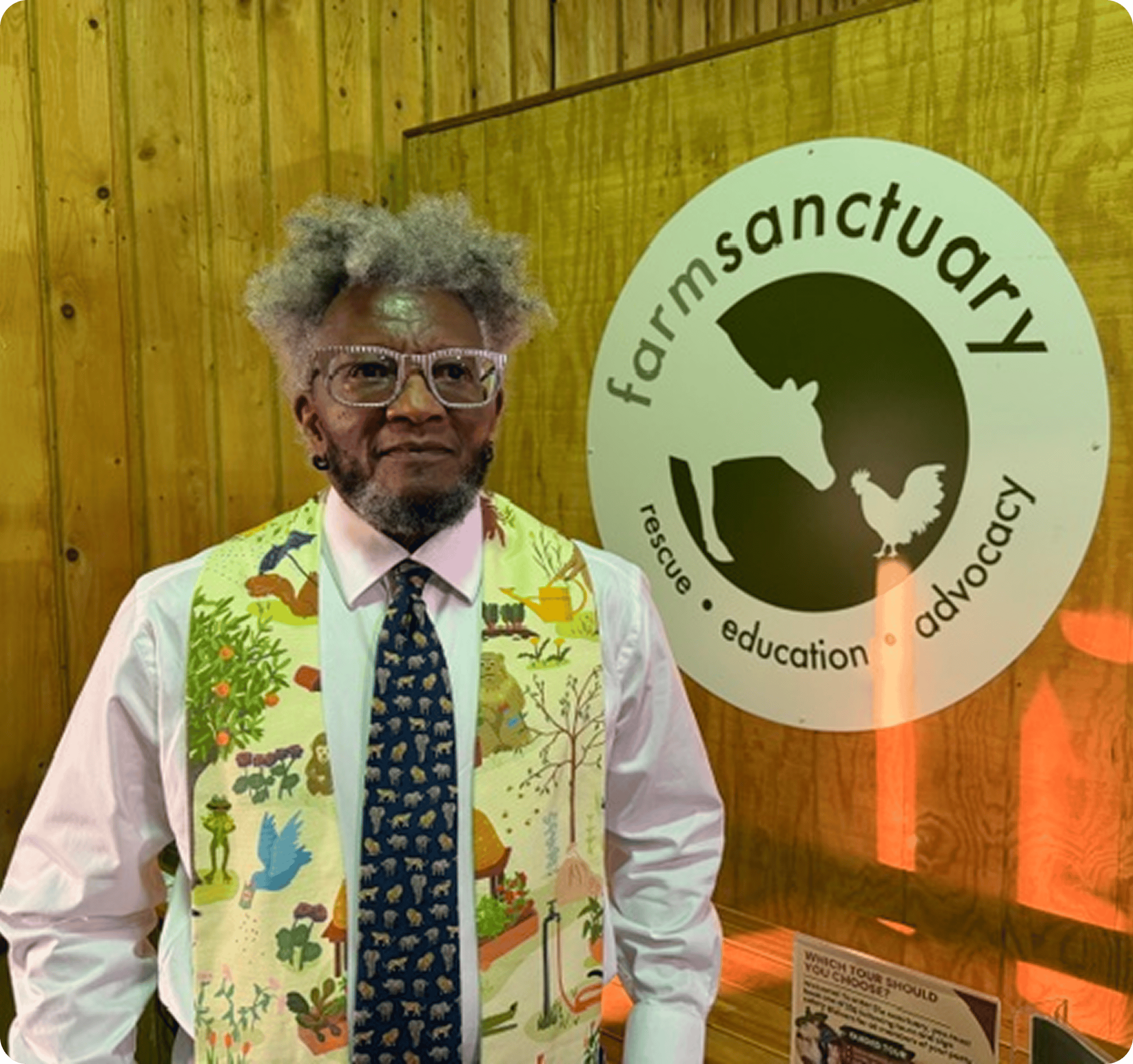 Man standing by Farm Sanctuary sign.