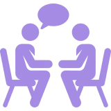 Two people talking at a table icon.